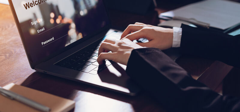 Hands typing on a laptop using a secure mailing list
